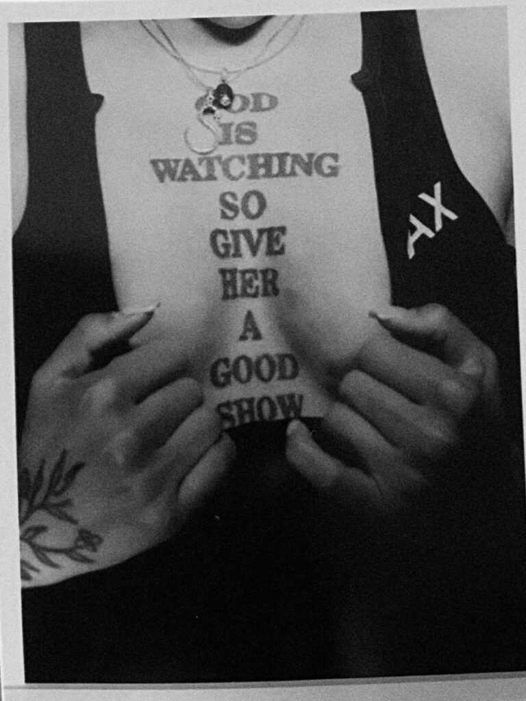 Picture of Mistrix Syx chest tattoo where it says 'God is watching so give her a good show'. 